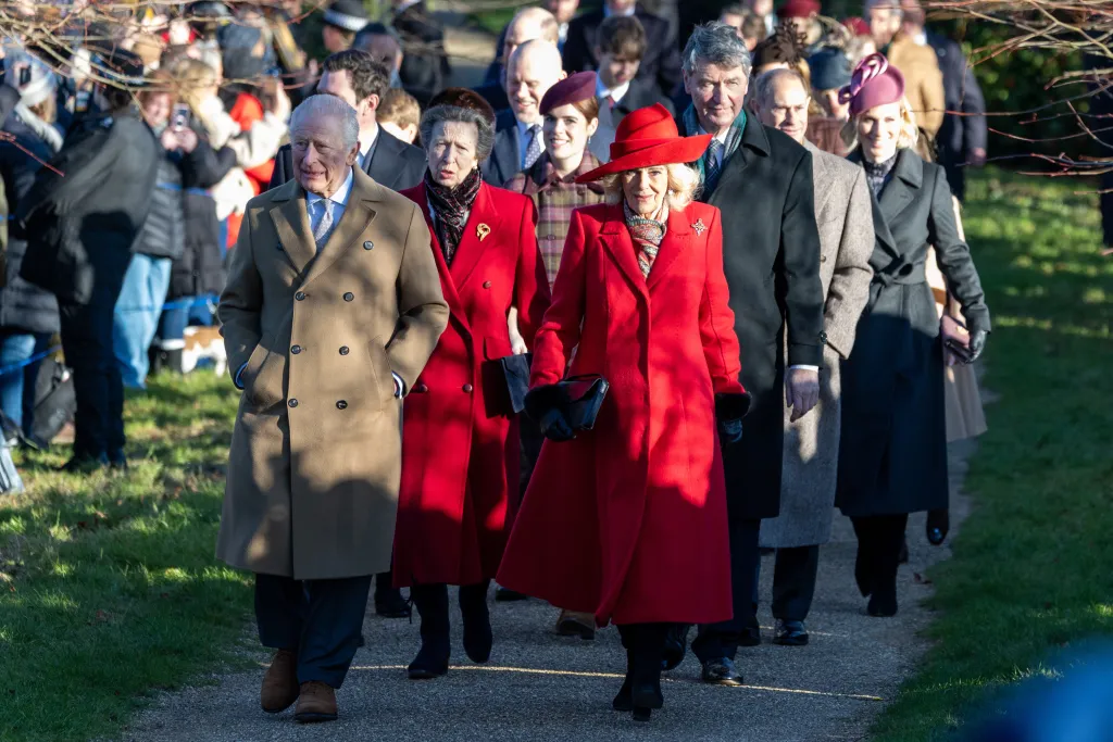 King Charles and Queen Camilla, in a red coat and hat, arriving with other members of the Royal Family at St Mary Magdalene Church.