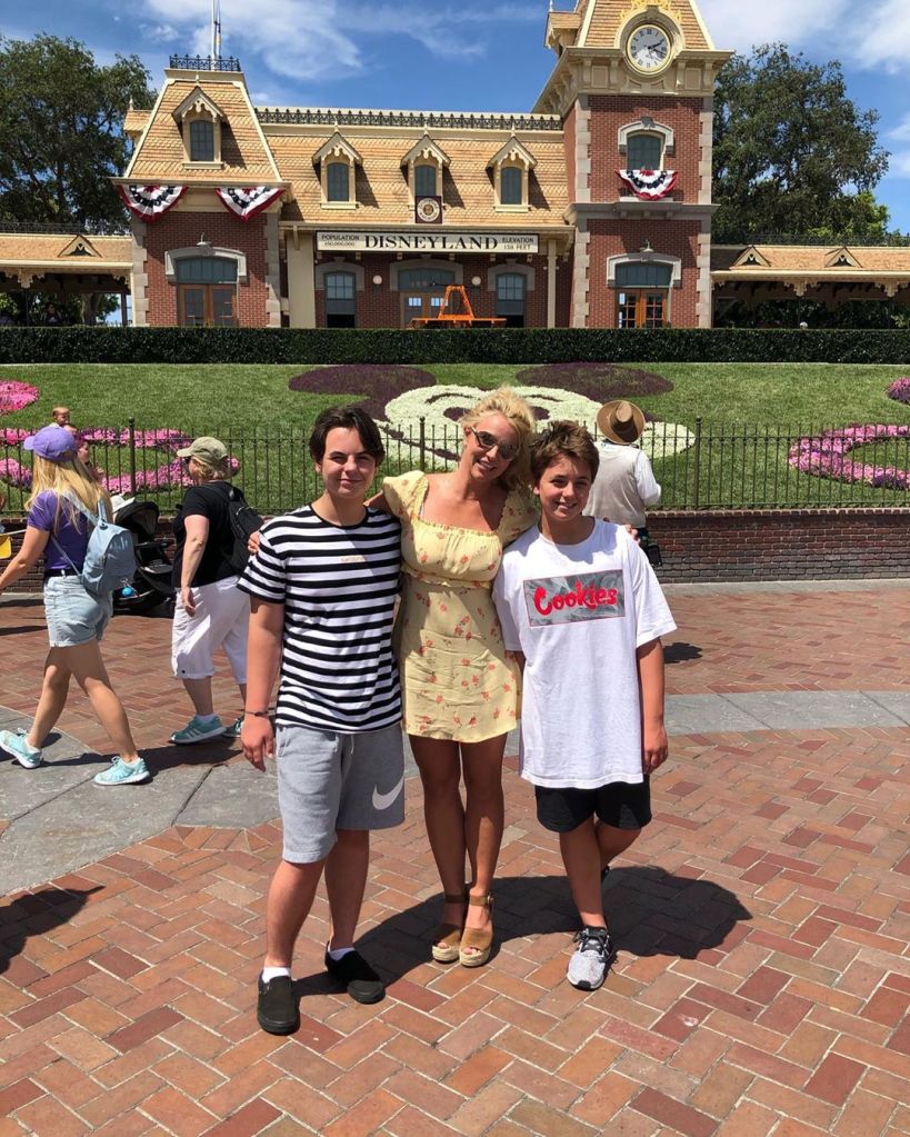 Britney Spears smiling with her two sons at Disneyland.
