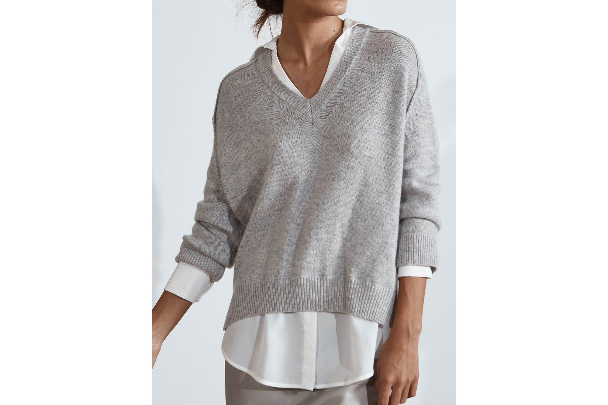 A model in a layered V-neck sweater