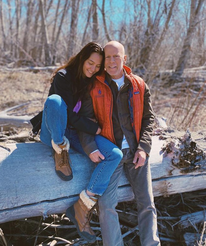 Bruce Willis and his wife Emma Heming Willis embracing outdoors.
