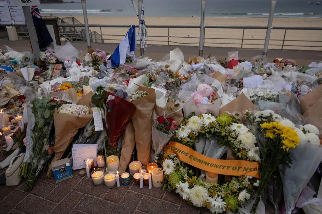 A memorial with flowers and candles is set up behind Bondi Beach on Dec. 21, 2025.