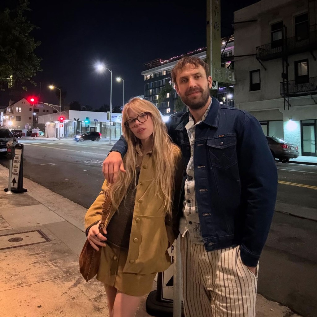 Carly Rae Jepsen and Cole M.G.N. standing together on a city sidewalk at night.
