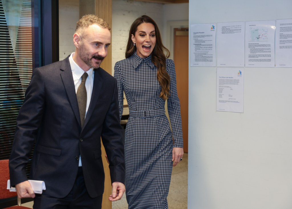 Catherine, Princess of Wales, in a houndstooth dress and a man in a suit, walking at the Anna Freud Charity.