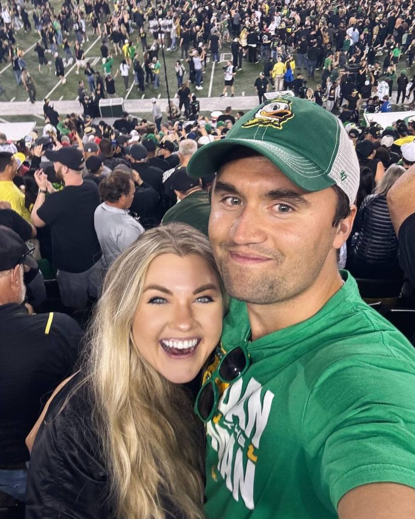 Charlie and Erika Kirk smiling at a football game.