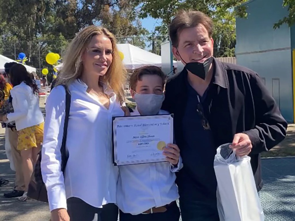 Charlie Sheen and Brooke Mueller with their son displaying a diploma.