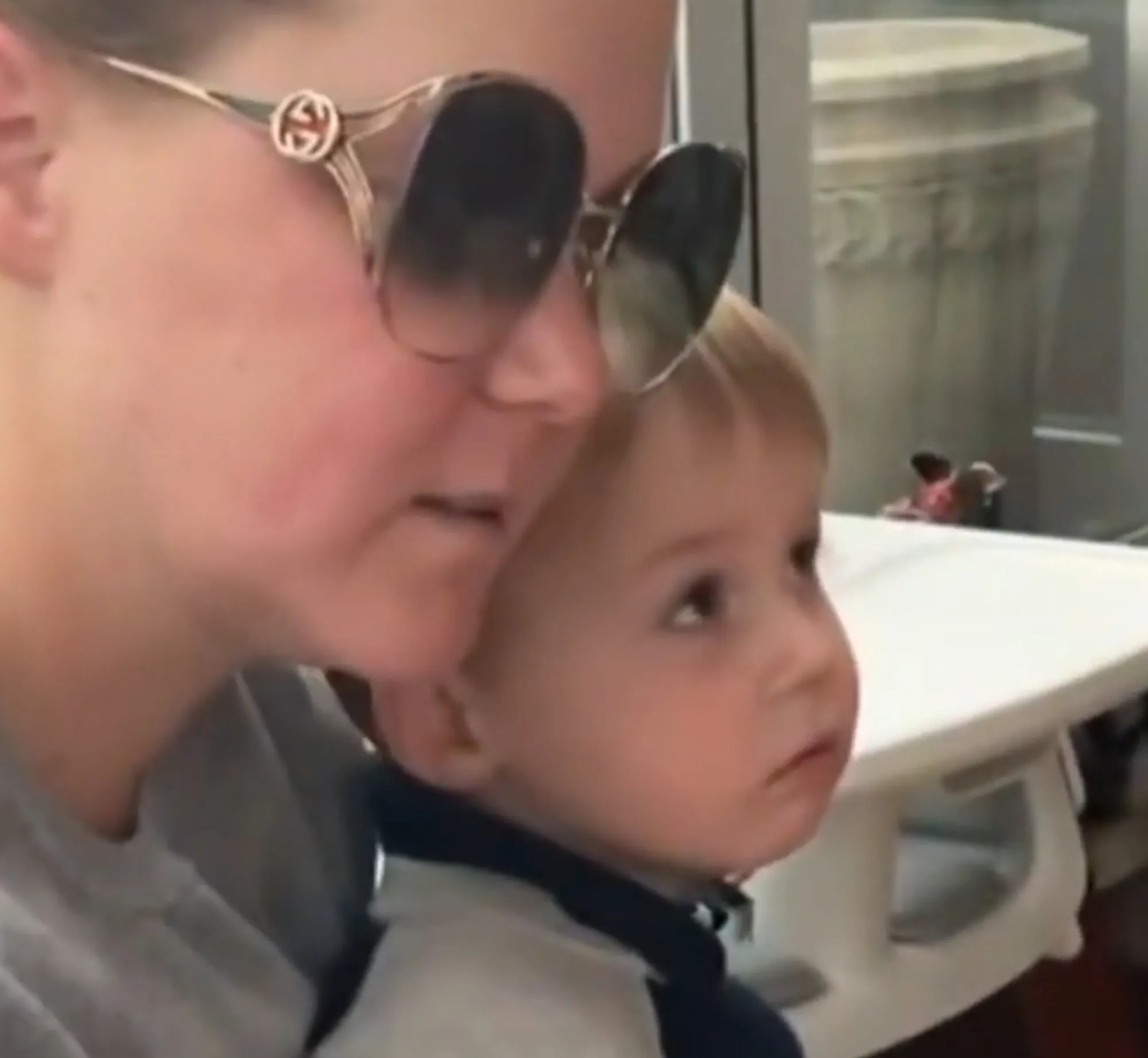 Amy Schumer with sunglasses holding her son Gene on her lap.