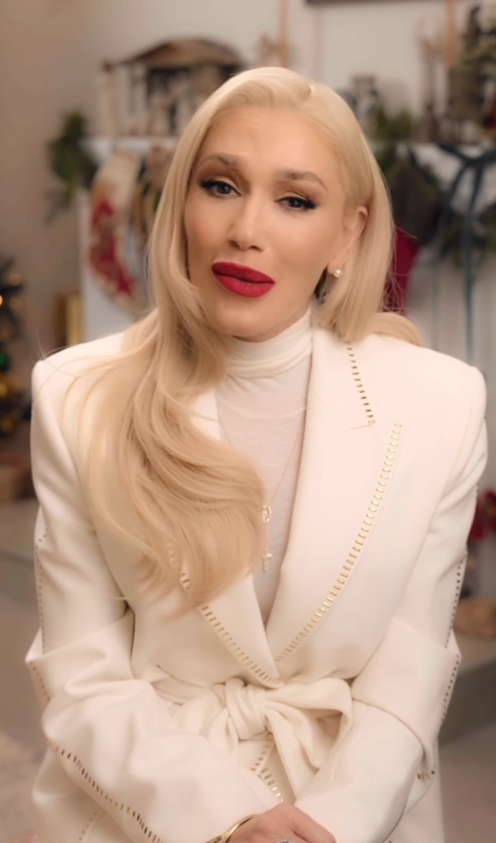 Gwen Stefani in a white blazer and red lipstick.