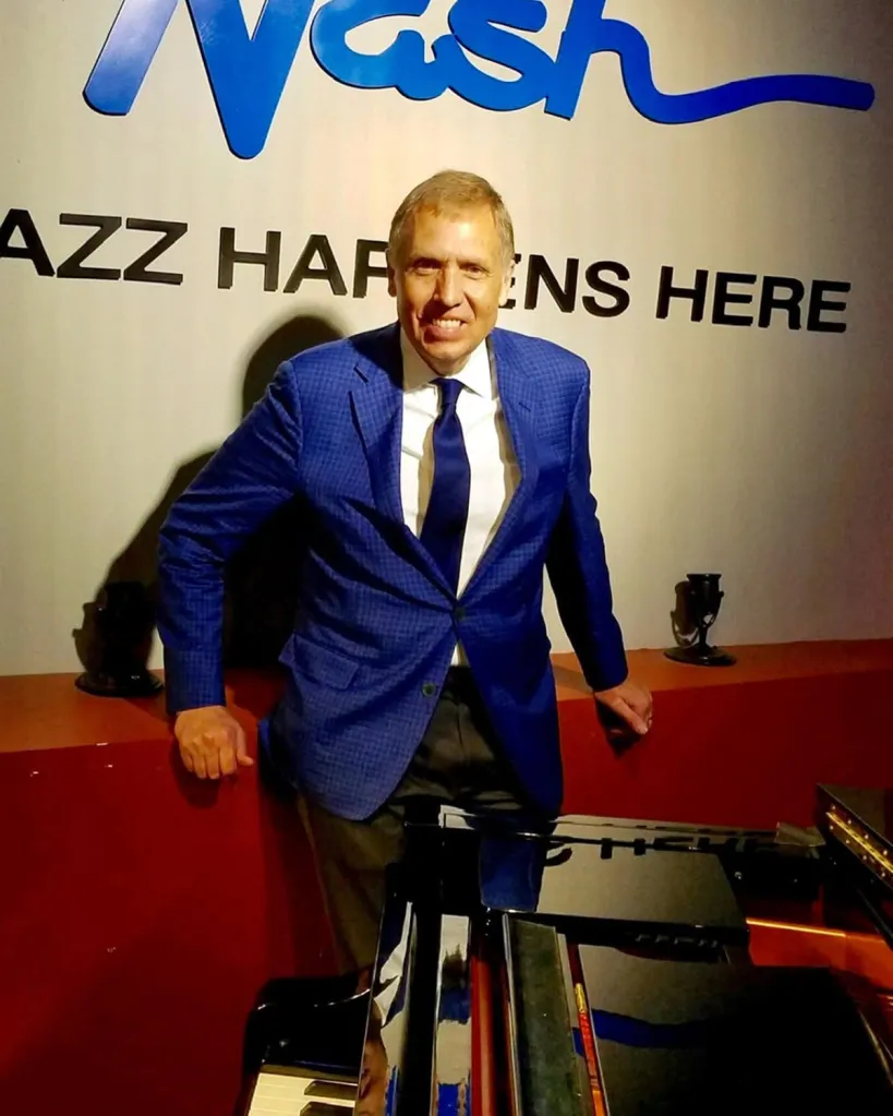 Chuck Redd posing with a piano at a 