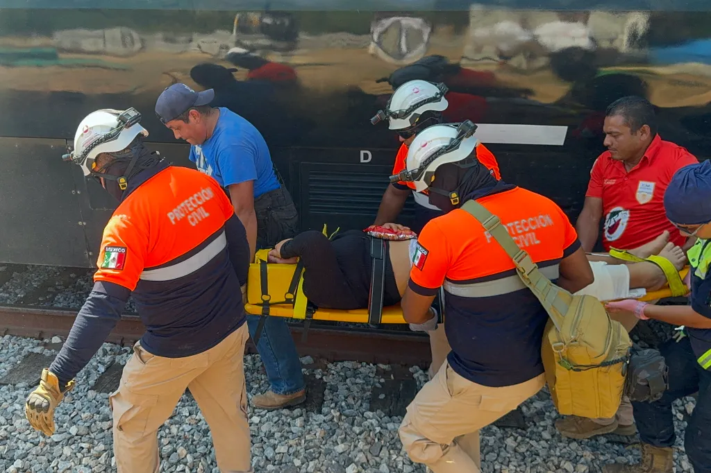 Civil Protection members rescue a woman from a derailed train.