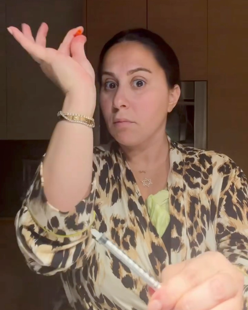 Claudia Oshry holding a syringe with medication.