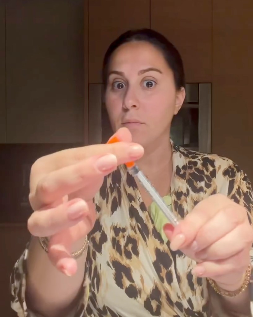 Claudia Oshry holding a weight-loss drug injection.