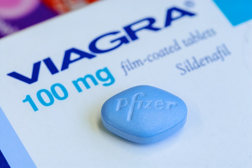 A close up of a blue Pfizer Viagra 100 mg tablet.