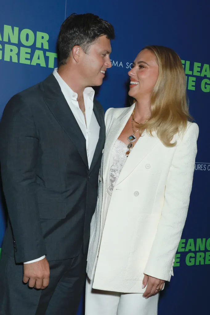 Colin Jost and Scarlett Johansson smiling at each other.
