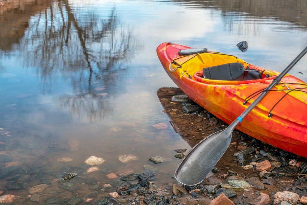 An orange kayak on a lake shore. Neither the father nor son was wearing a life jacket, despite a state law mandating children 12 and under to wear one while on the water.