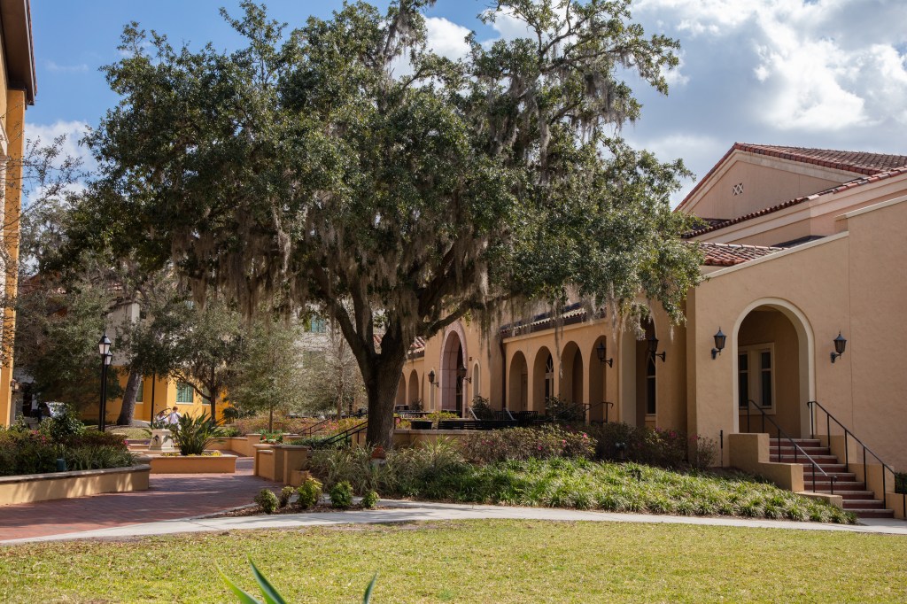 The Cornell Campus Center at Rollins College, featuring arched entrances and a tree with Spanish moss.
