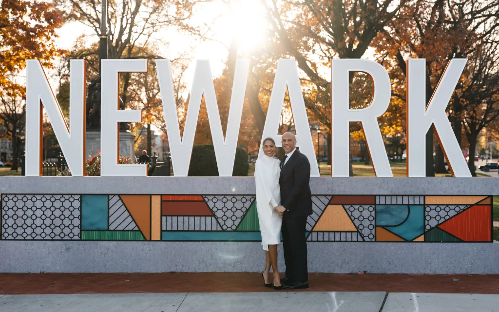 Cory Booker and Alexis Lewis standing in front of a 