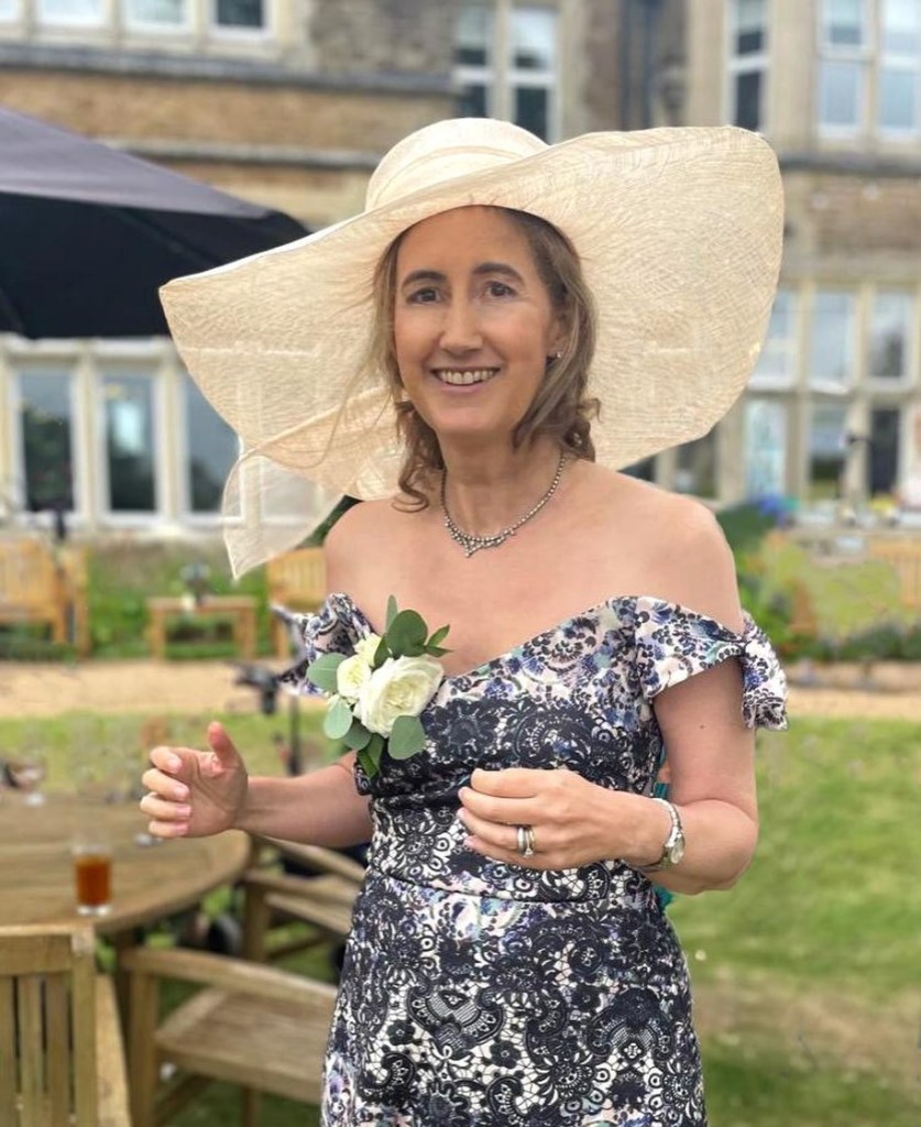 A woman in a hat and floral dress.