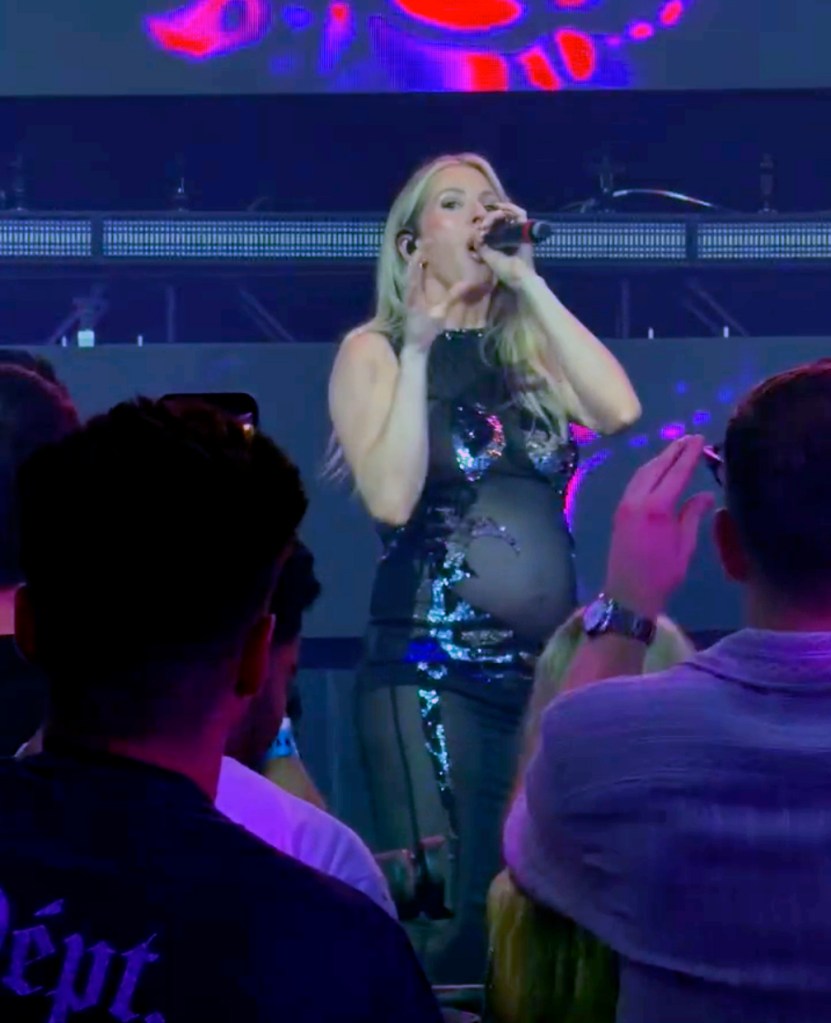 Ellie Goulding performing while pregnant in a black sequined dress.