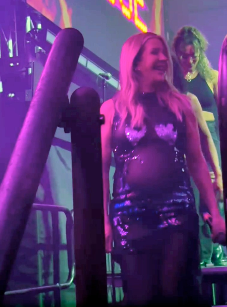 Ellie Goulding performing while pregnant in a sparkly dress.