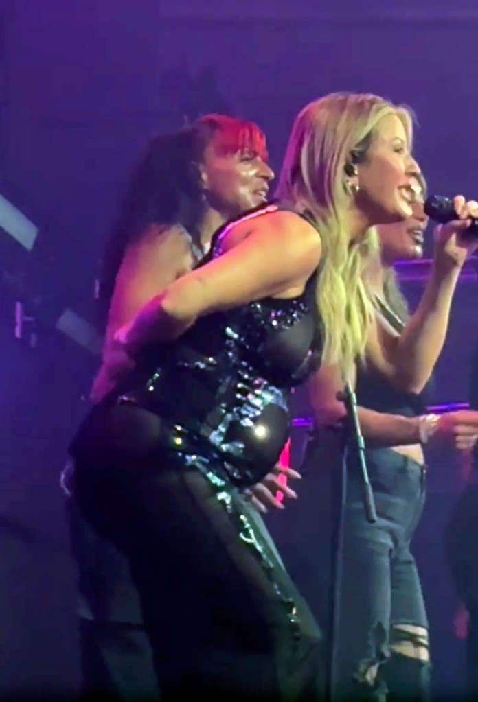 Ellie Goulding performing while pregnant in a sequined top and sheer pants.