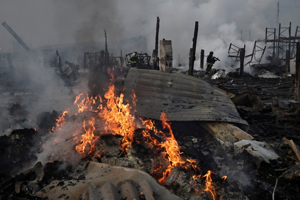 Flames burn through the remnants of a warehouse destroyed by a Russian airstrike in Novi Petrivtski, Ukraine, on Dec. 6, 2025.