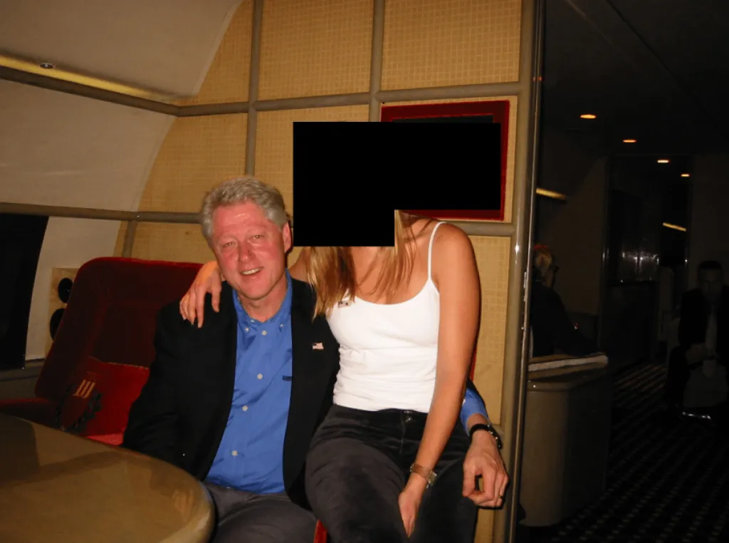 Bill Clinton seated with an unidentified woman whose face is blacked out.