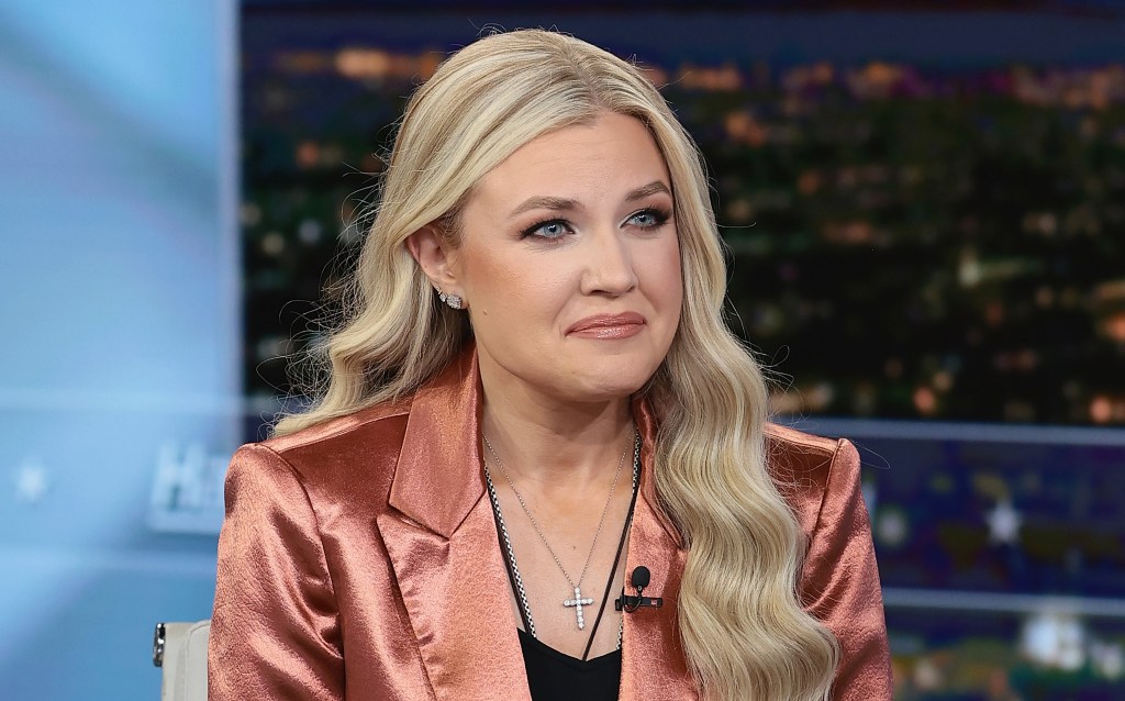 Erika Kirk, with long blonde hair and wearing a shiny copper-colored blazer over a black top, discusses her new book.