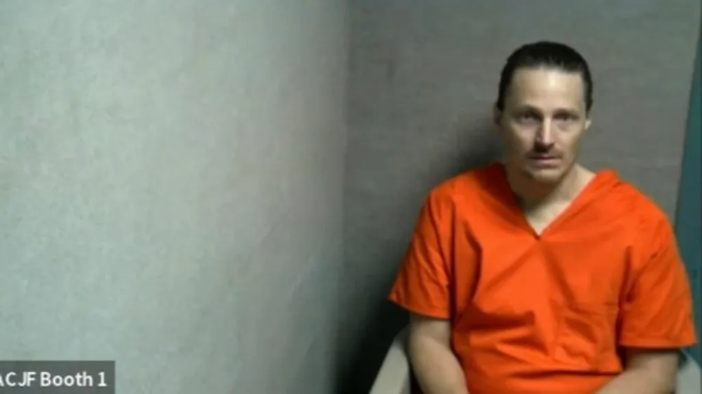 Ernest Heinz in an orange jumpsuit.