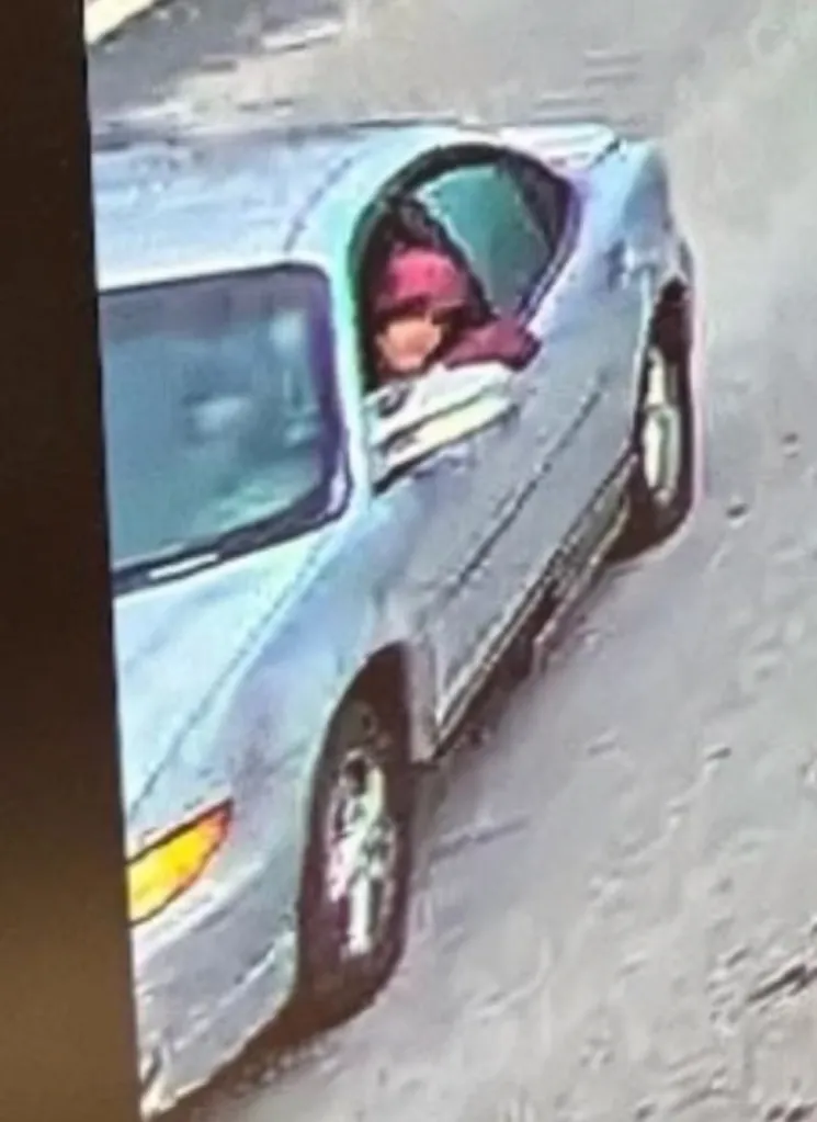 Timothy Shane in a light-colored car.