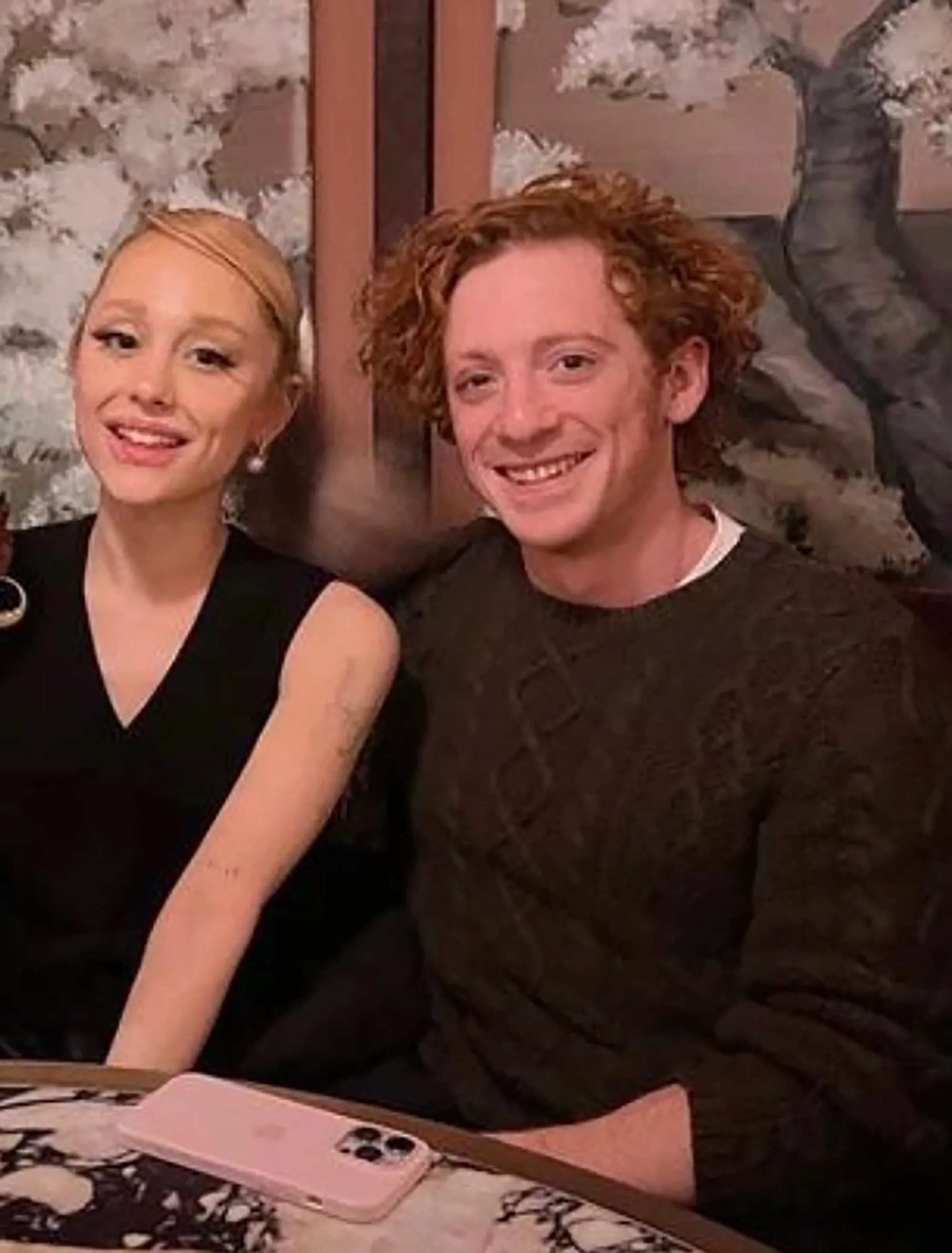 Ethan Slater and Ariana Grande smiling.