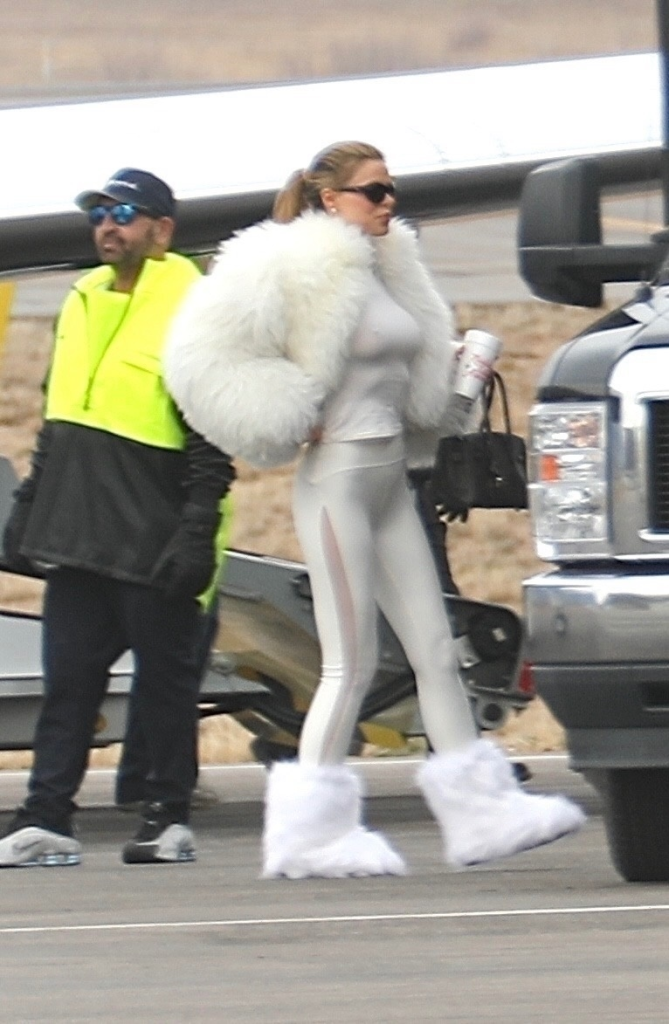 Brooks Nader in Aspen, wearing a white fur coat, white leggings, and white furry boots.