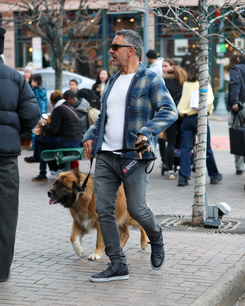 Mauricio Umansky walking his service dog on a leash while Christmas shopping.