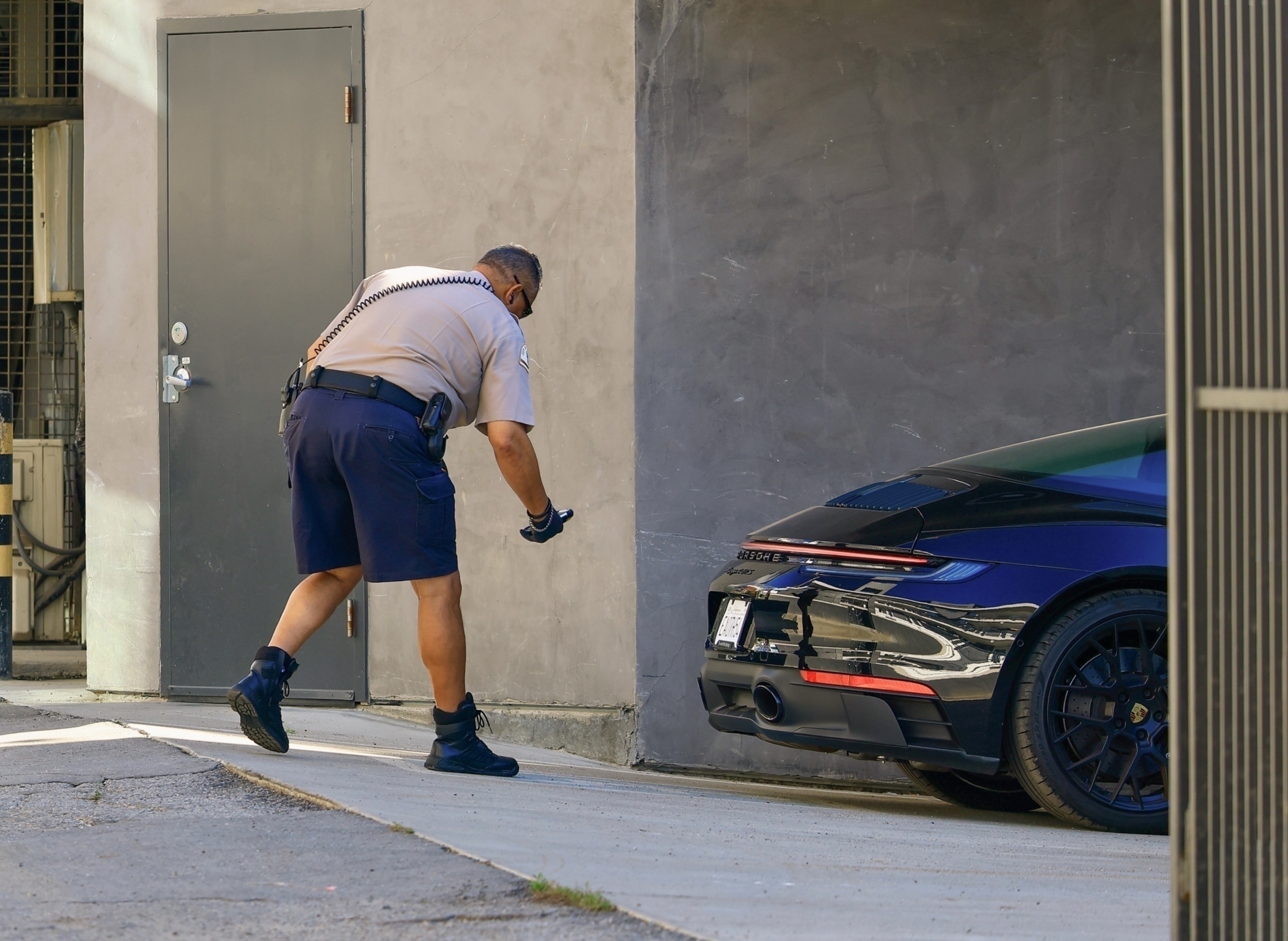 A man, a parking officer, issues a citation for a car in a handicap spot.