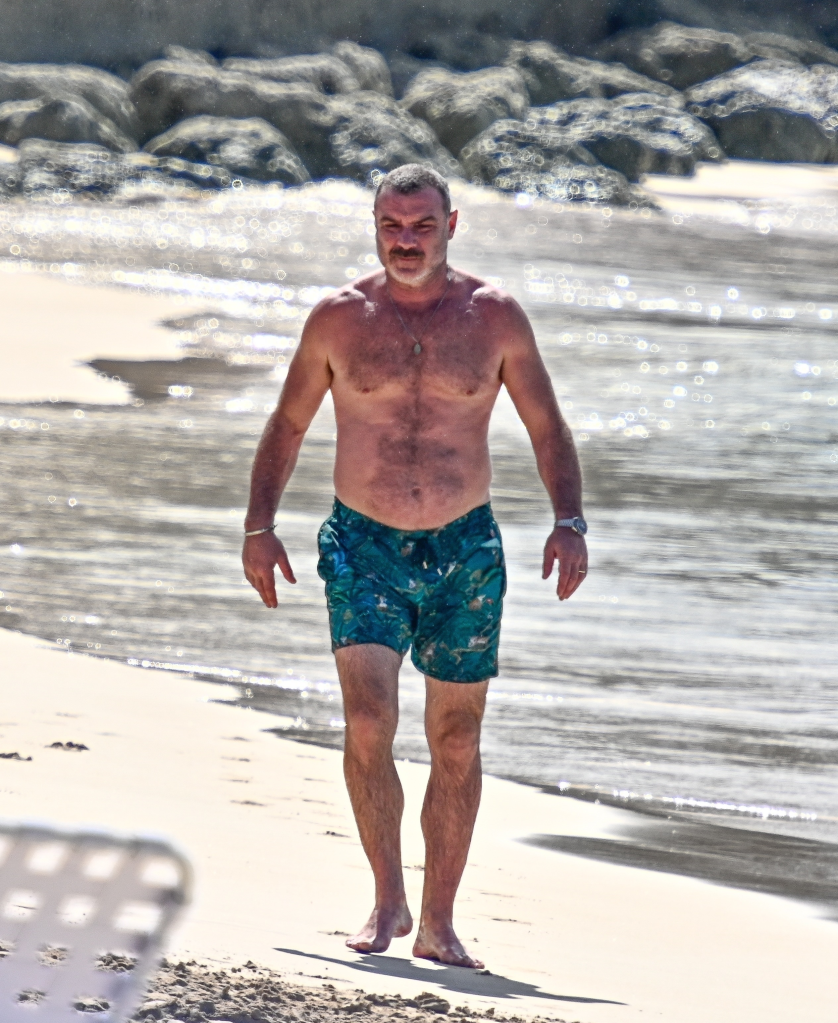 Liev Schreiber walking on a beach in Barbados.