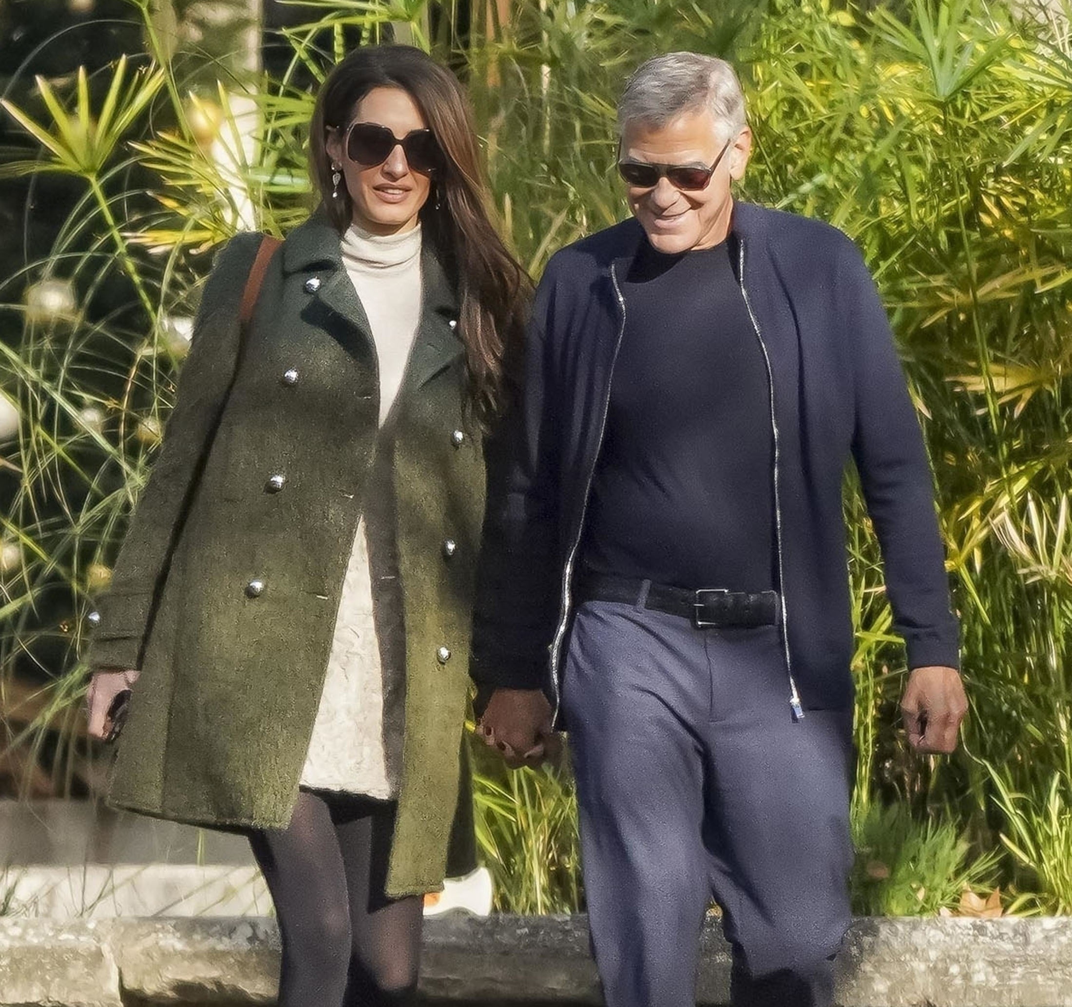 George and Amal Clooney walking hand in hand.