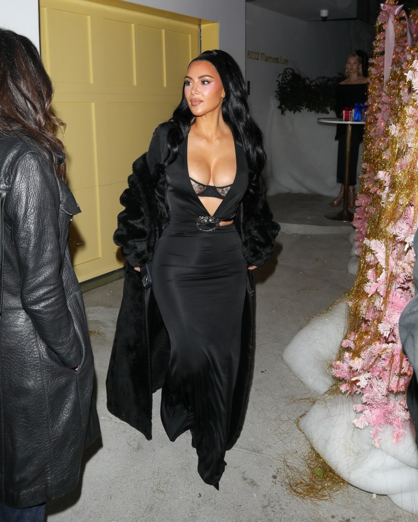 Kim Kardashian in a black gown with a lace-detail bodice and fur-trimmed coat, leaving Vas J Morgan’s Hollywood party.
