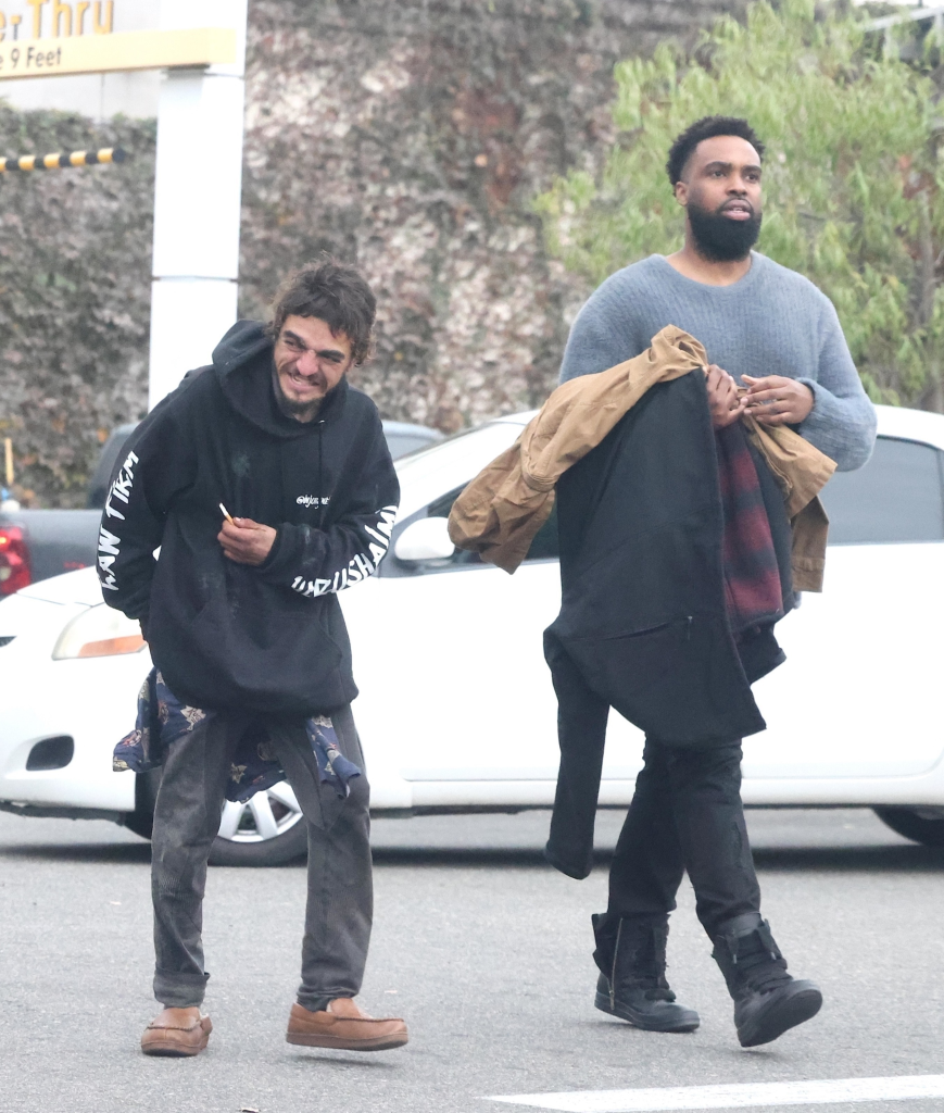 Two people walking on a street.