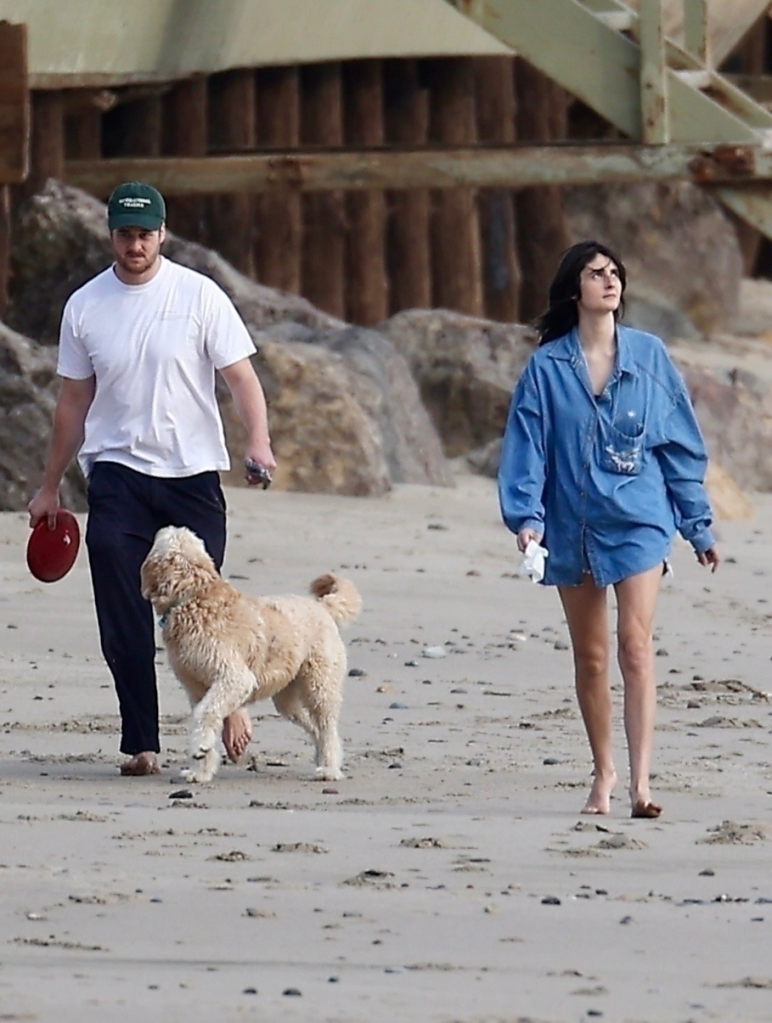 Romy Reiner and Alex Siliberg walking a dog on Malibu beach.