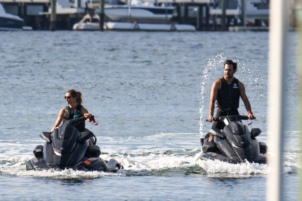 Gisele Bündchen and Joaquim Valente riding jet skis across Miami Bay.