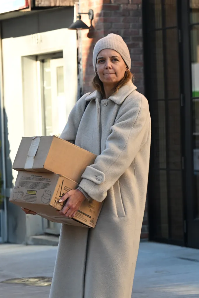 Katie Holmes carrying two cardboard boxes.