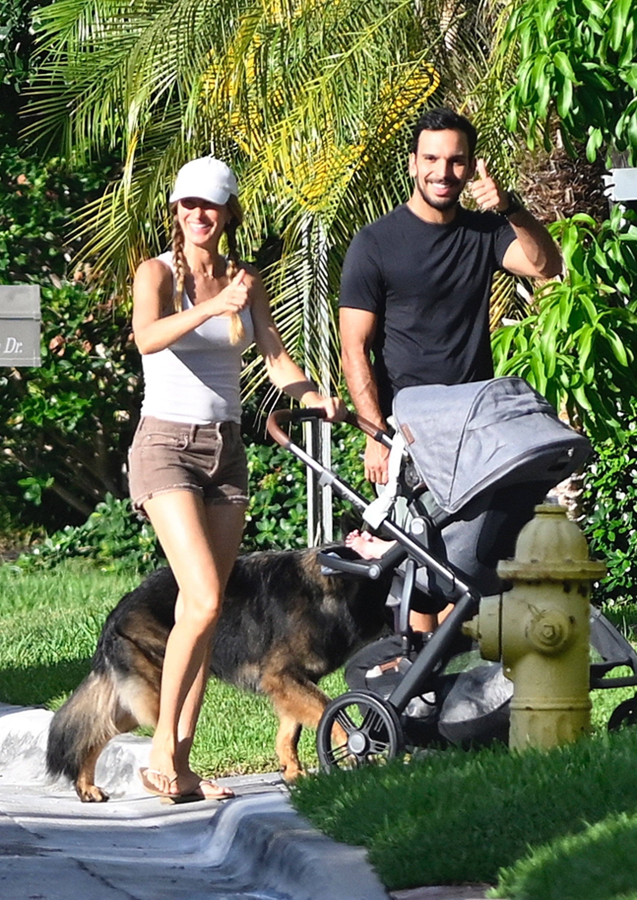 Gisele Bündchen and Joaquim Valente walking with their newborn baby and a dog.