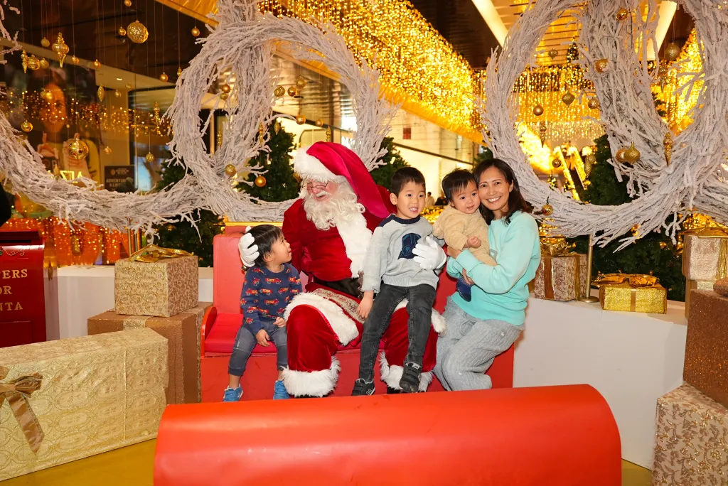 A family with two young children posing with Santa Claus in a holiday display at Hudson Yards.
