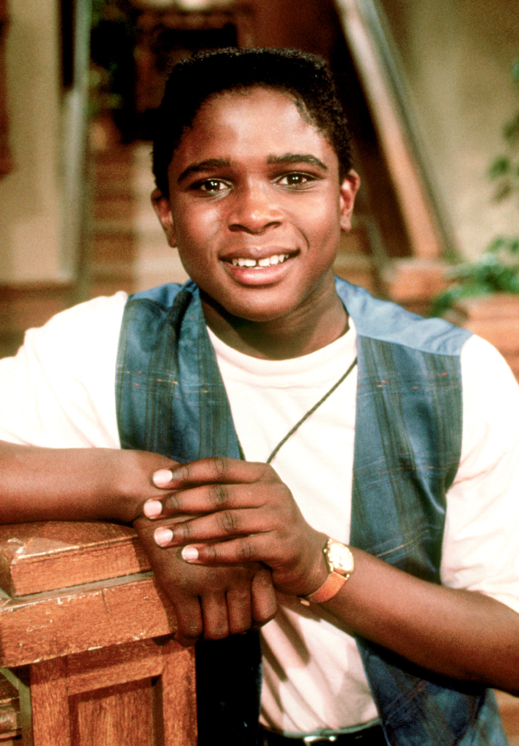 Darius McCrary in a light t-shirt and blue plaid vest for the TV series