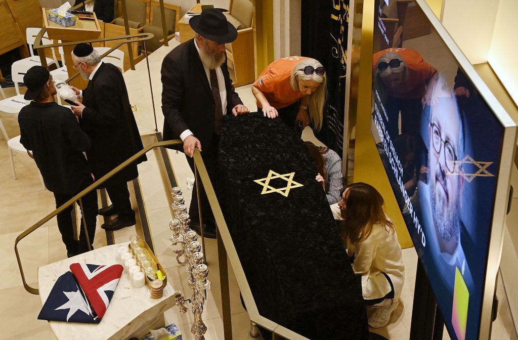 Family members lean over the casket of Rabbi Eli Schlanger during his funeral at Chabad of Bondi.