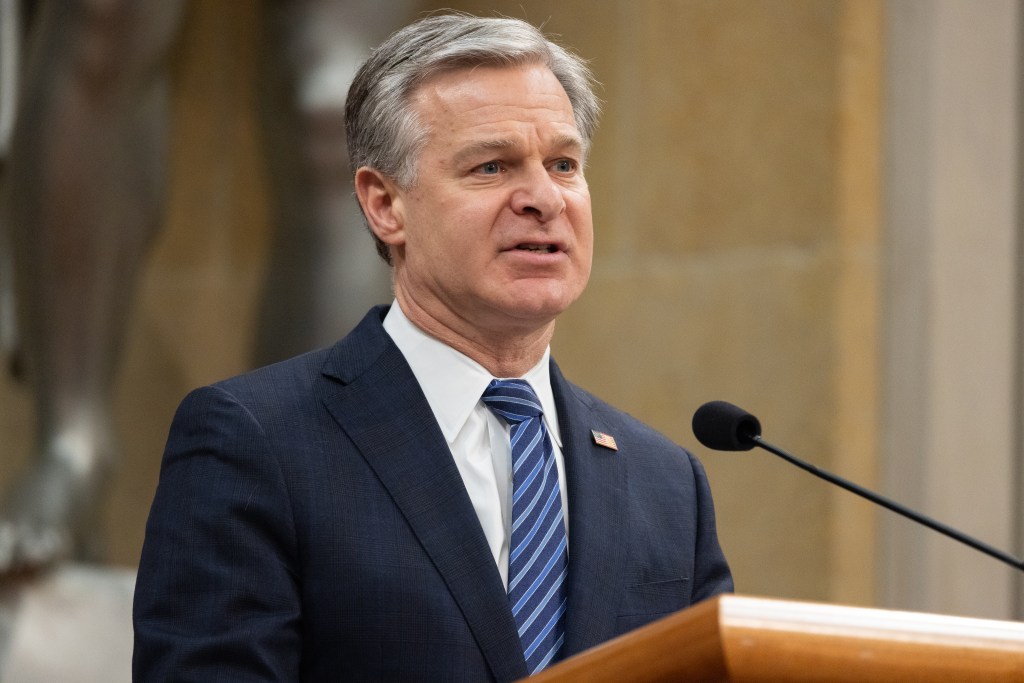 FBI Director Christopher Wray speaking at Attorney General Merrick Garland's farewell ceremony.