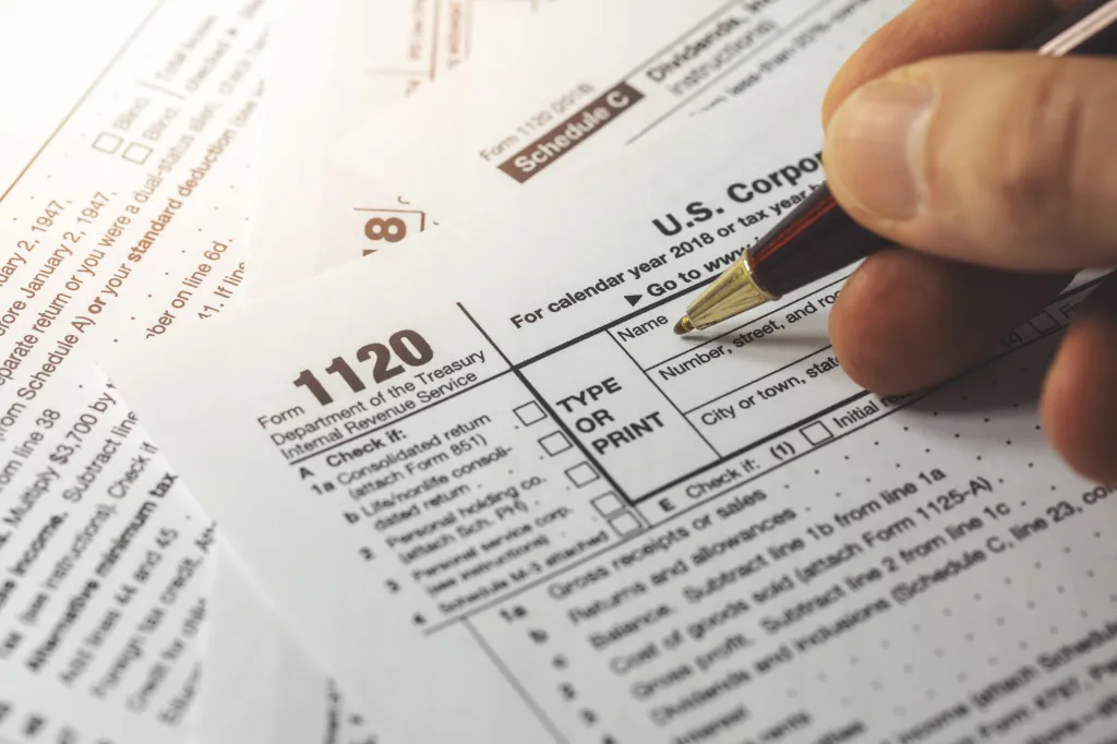 A person filling out a U.S. Corporation Income Tax Return Form 1120.