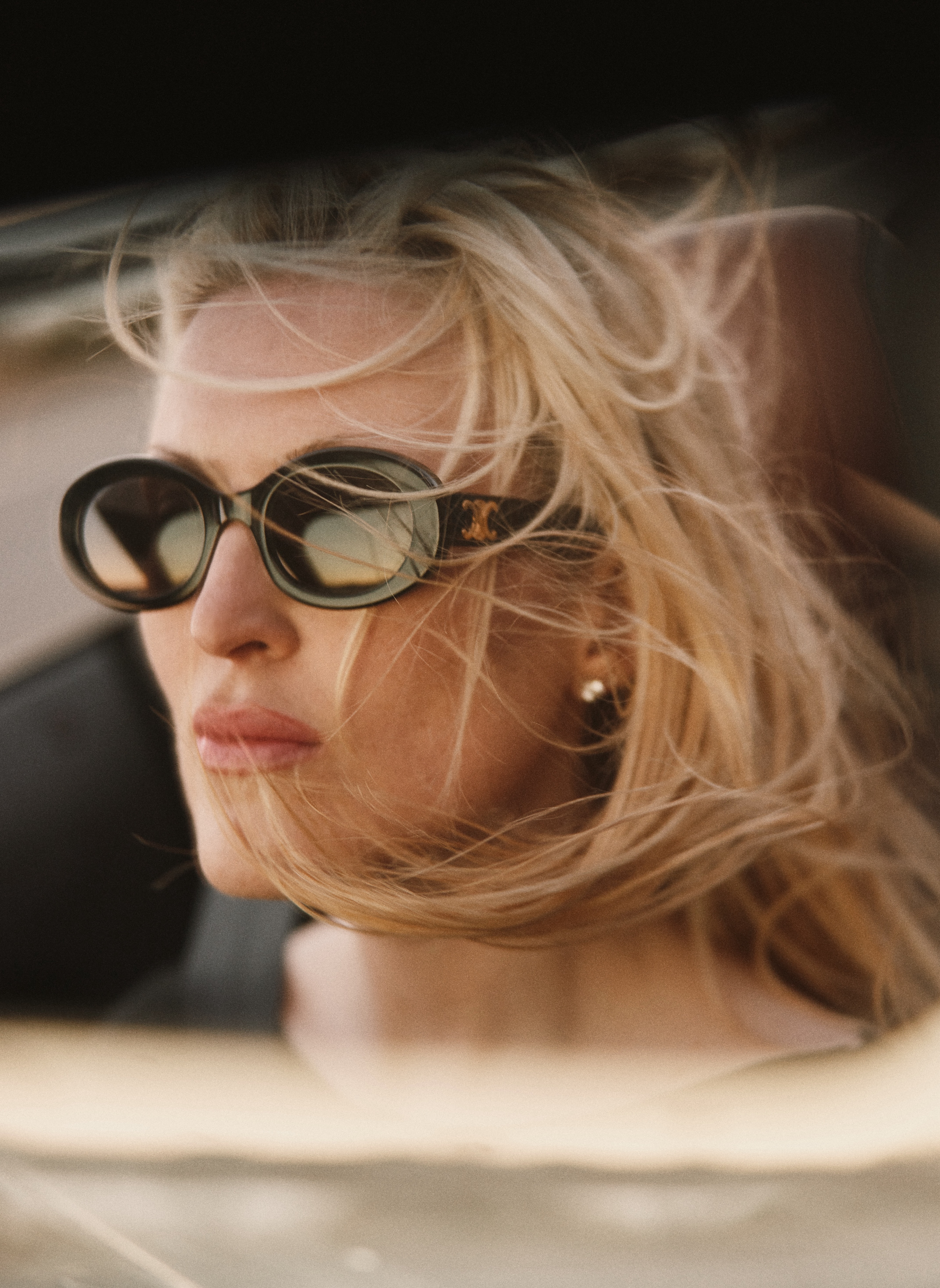 Olivia Nuzzi wearing sunglasses, with blonde hair flowing around her face.