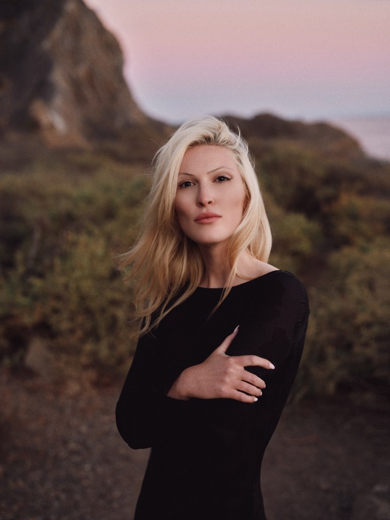 Olivia Nuzzi in a black dress with arms crossed.