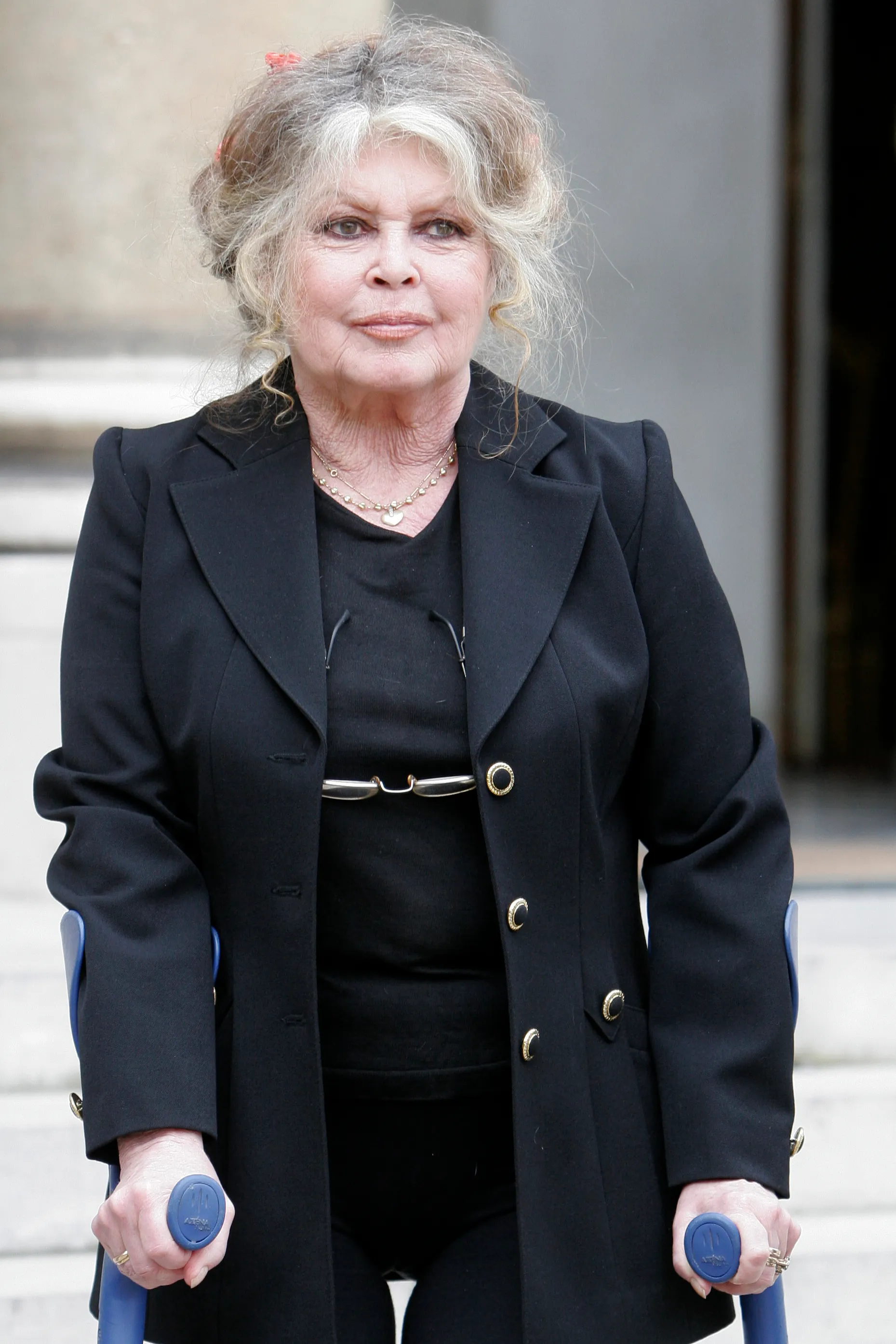 Former actress and animal rights activist Brigitte Bardot holding crutches.