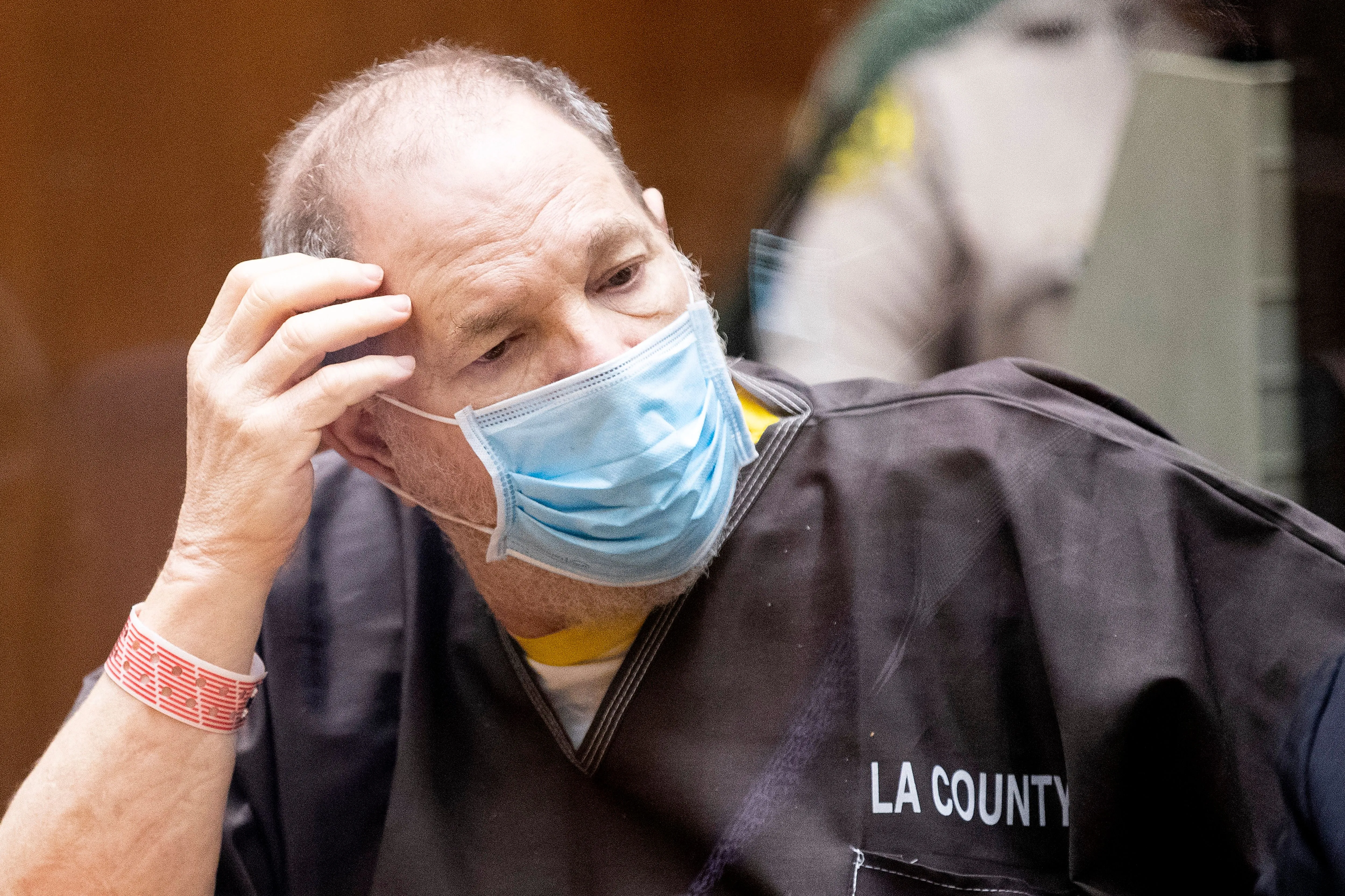 Harvey Weinstein in a light blue mask and dark 